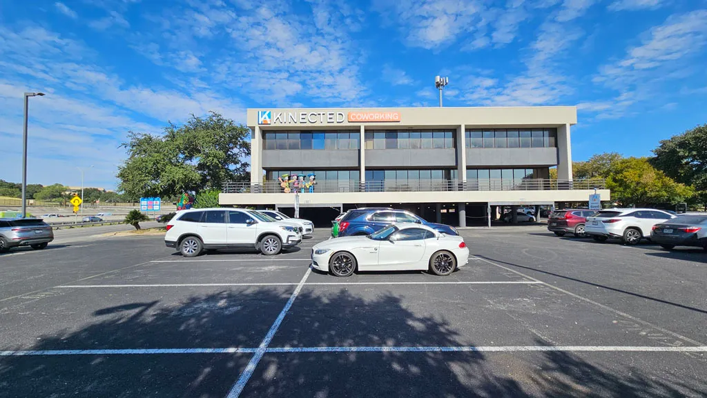 Front view of the Kinected Coworking building with parking lot from the street