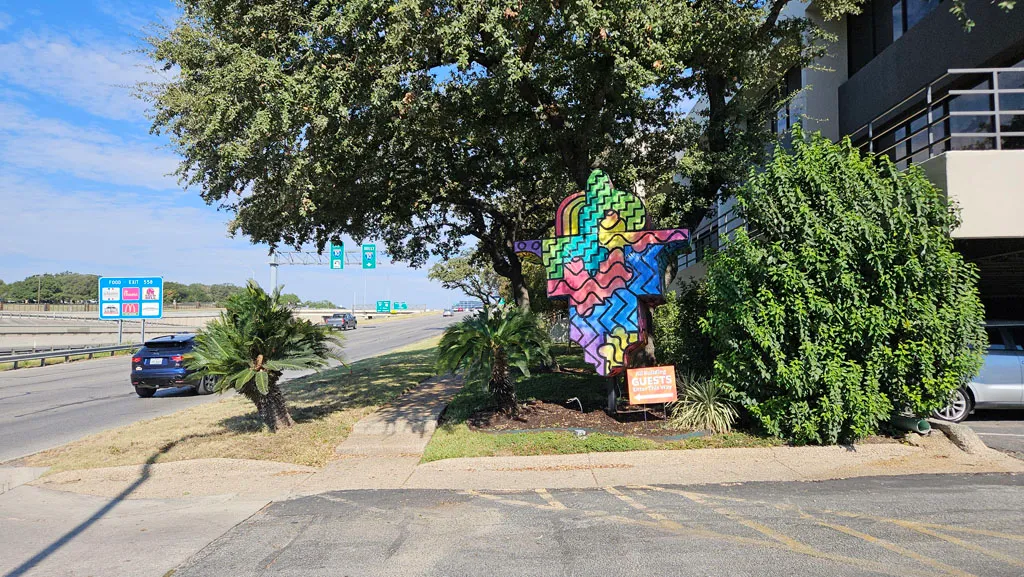 Colorful geometric mural visible from the I-10 access road near the love.marketing office