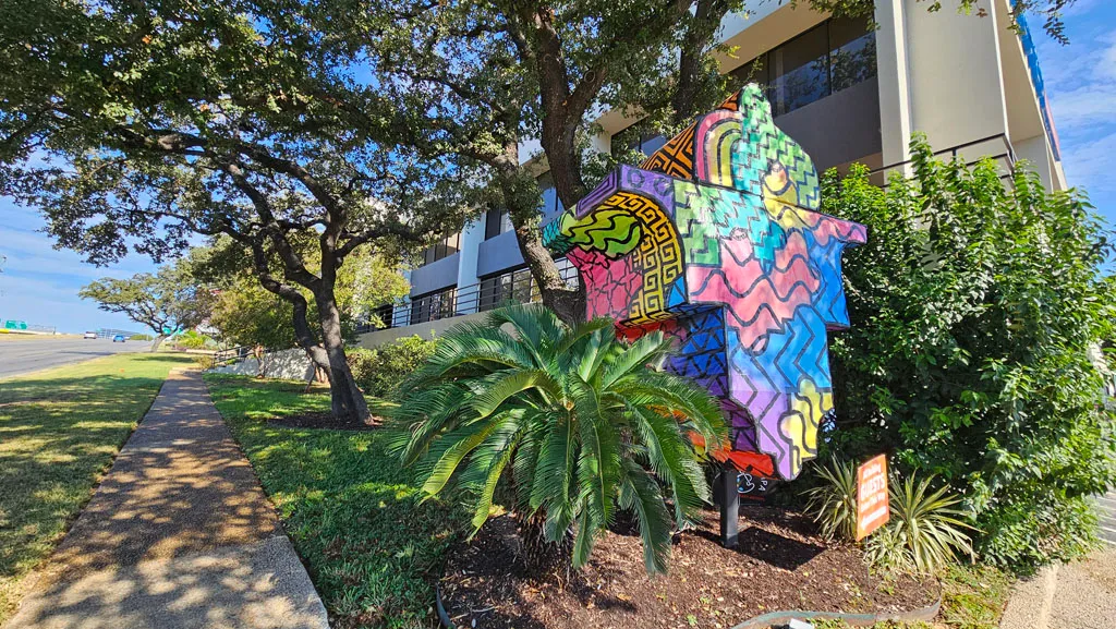 Walkway leading past the colorful mural toward the building entrance