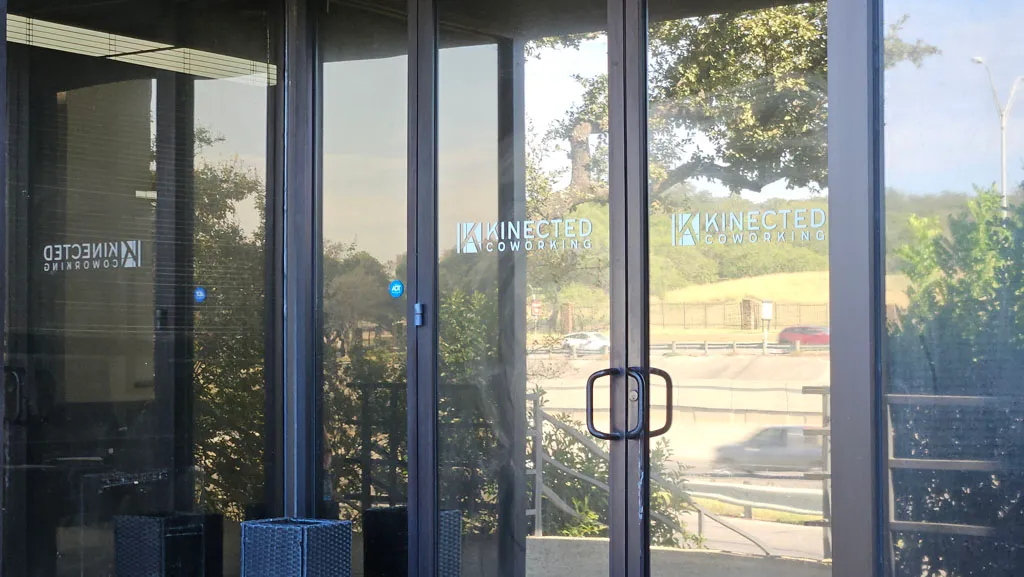 Glass front doors with Kinected Coworking logo at the building entrance